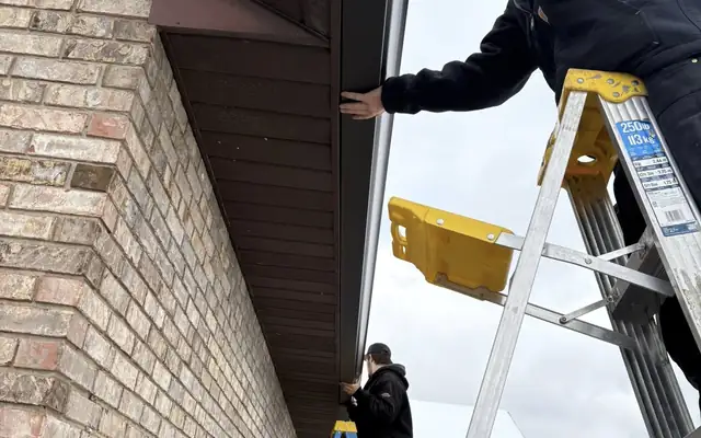 Premier Gutters installer mounting a new seamless gutter