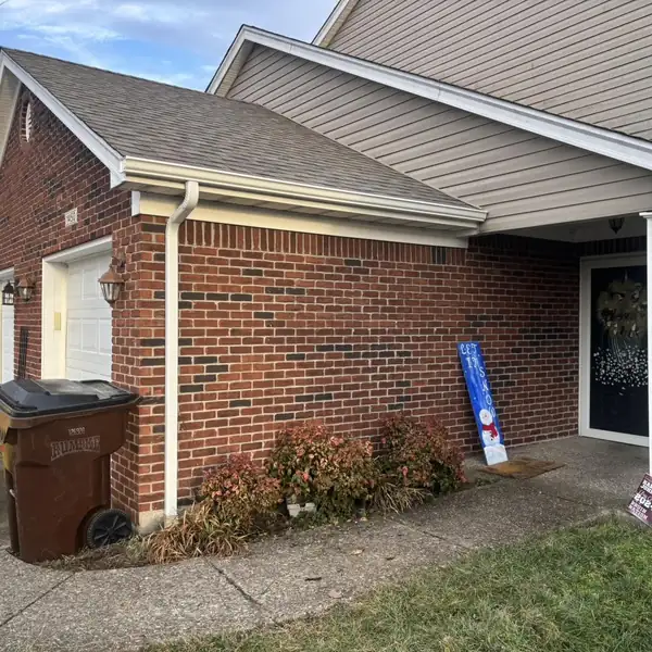 Home with new white gutters and downspout