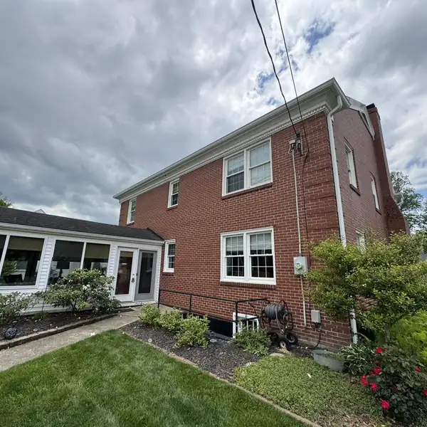 Brick house with white seamless gutters and downspouts