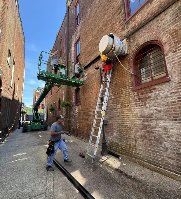 Premier Gutters crew installing gutters on a brick building